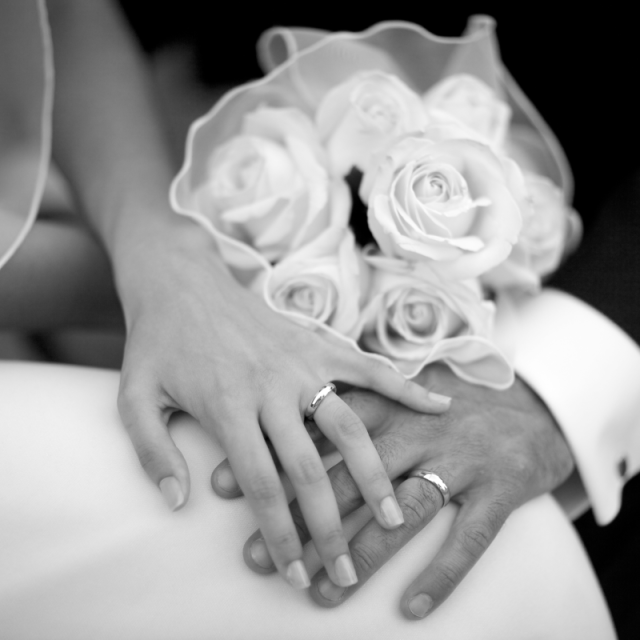 a bride and groom holding hands in grey color