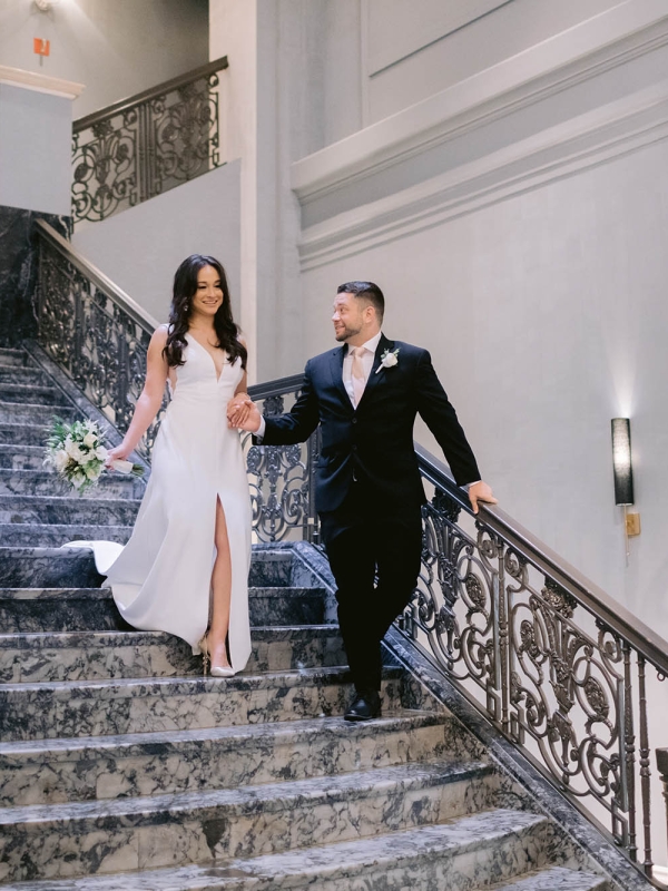 A bride and groom walking down the stairs at The Marker