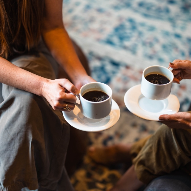 Two people enjoying cups of coffee at The Marker
